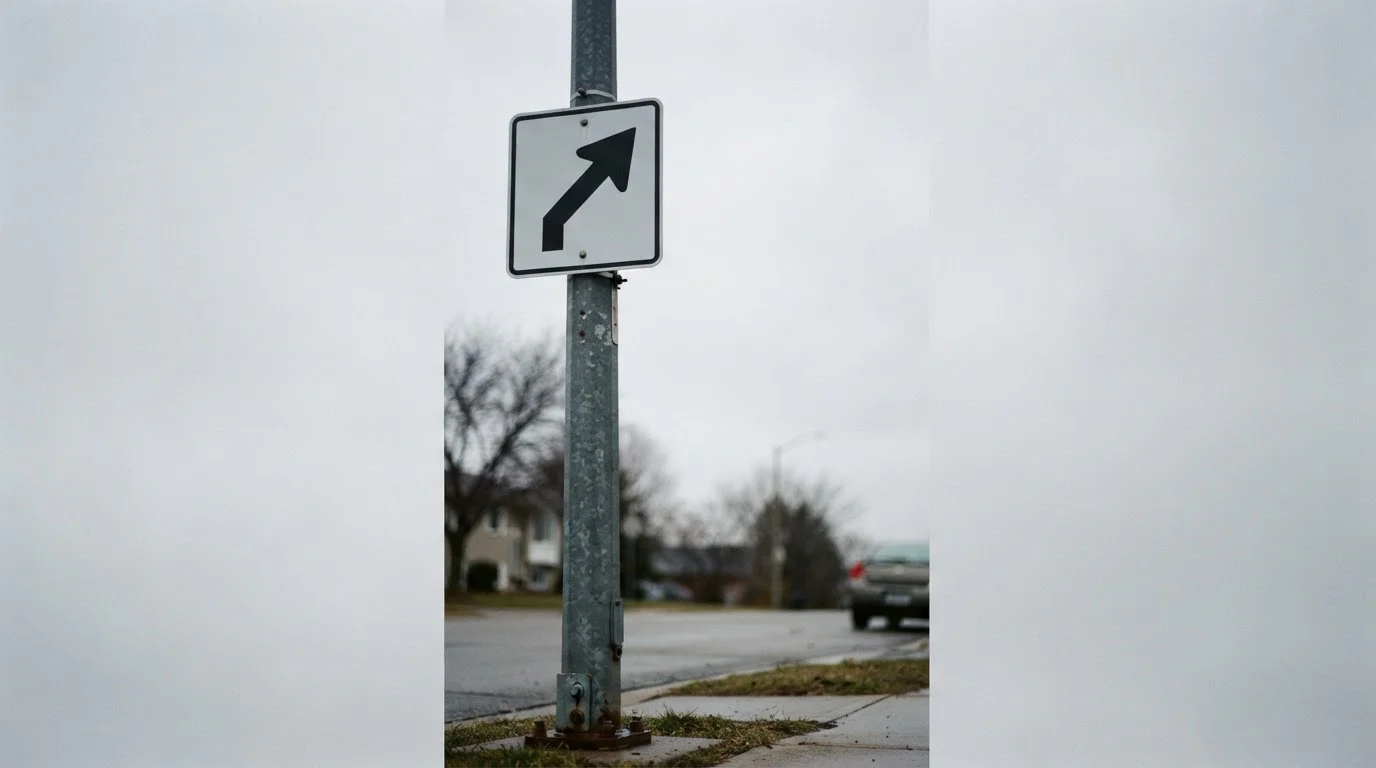 One way street sign photographed against a plain overcast sky